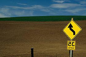 A speed limit is posted alongside a highway leading towards the valley. 